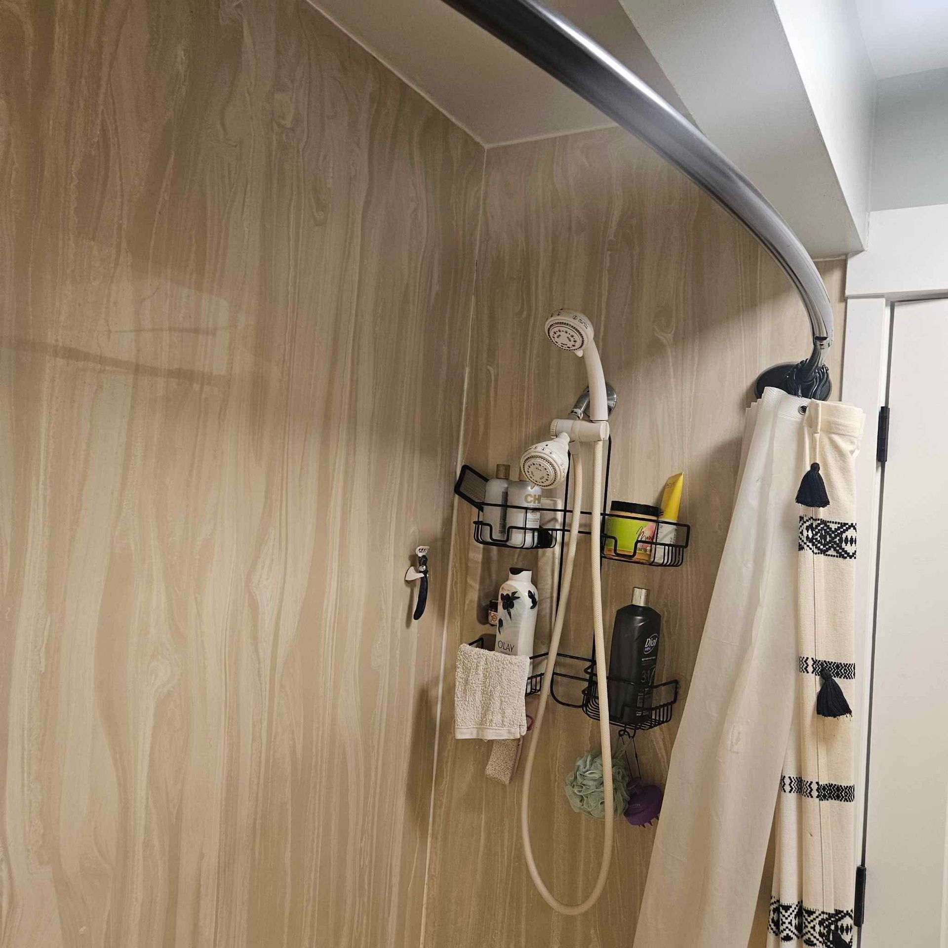 A bathroom with a shower head and a shower curtain.