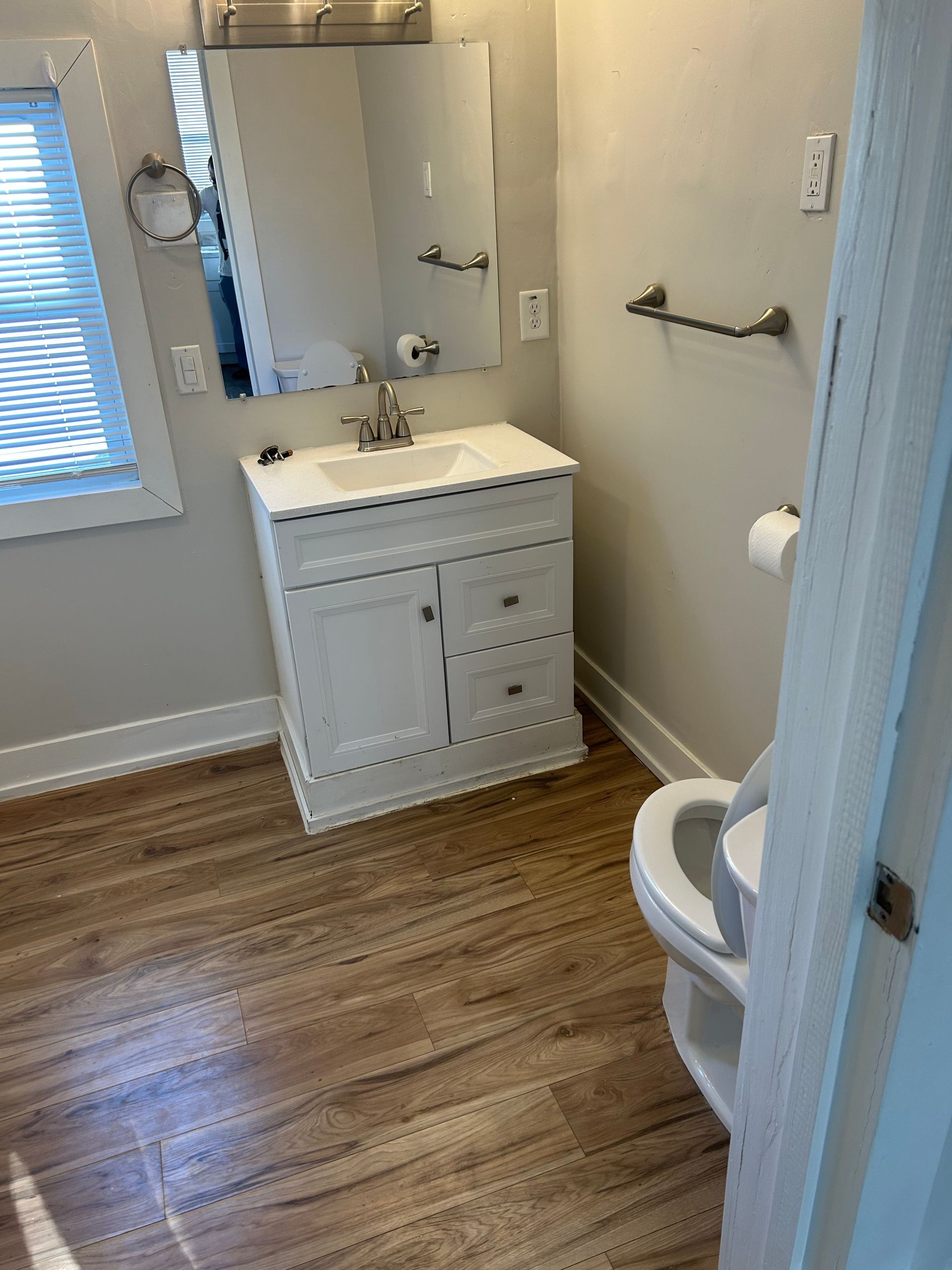 A bathroom with a sink , toilet and mirror.