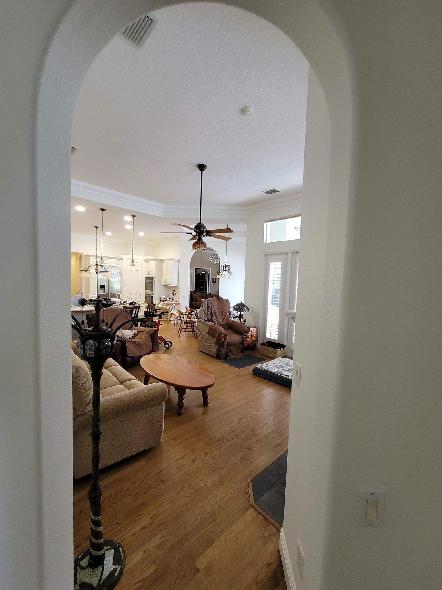 A living room with hardwood floors and a ceiling fan.