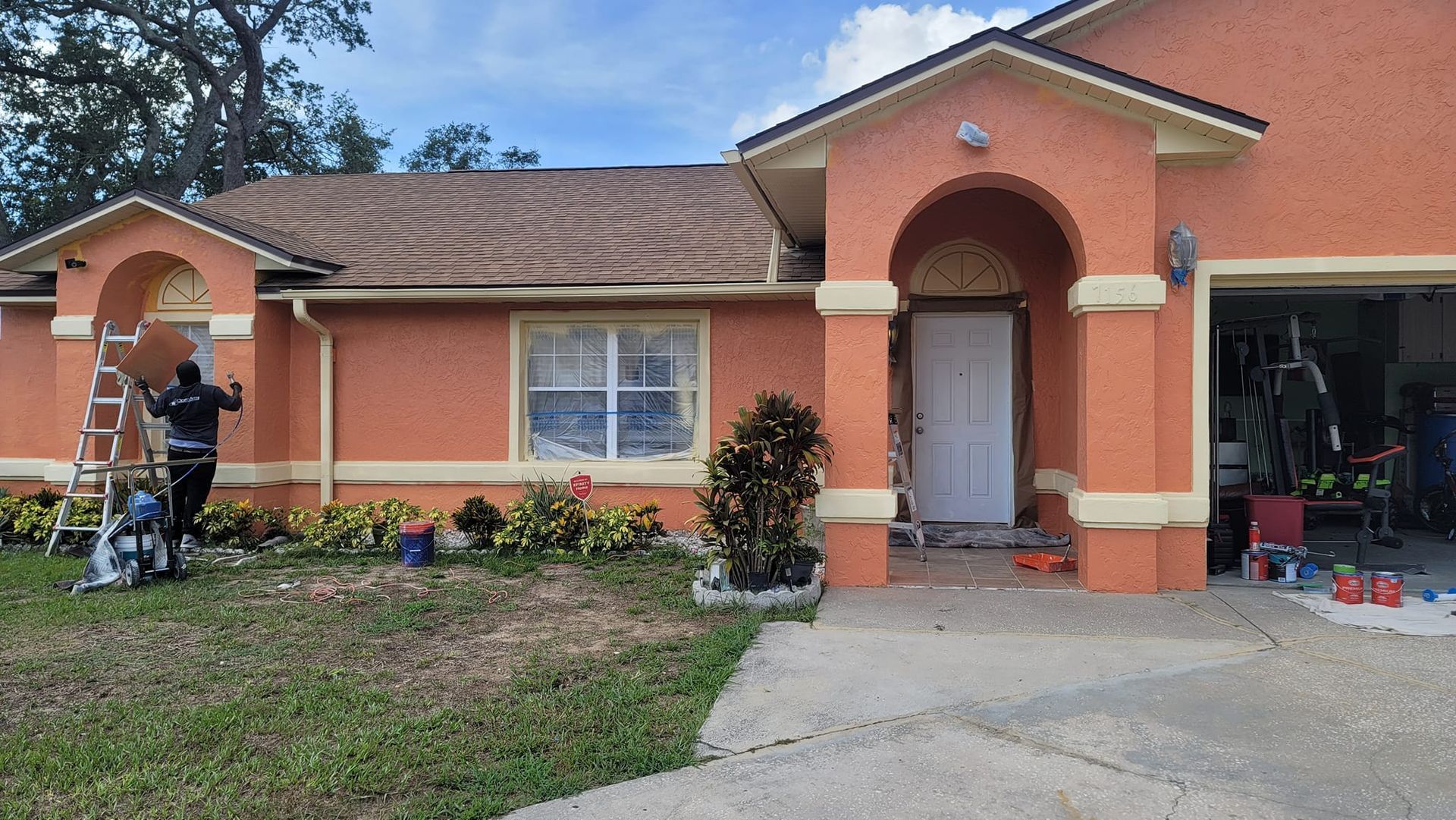 A man is painting the front of a house.