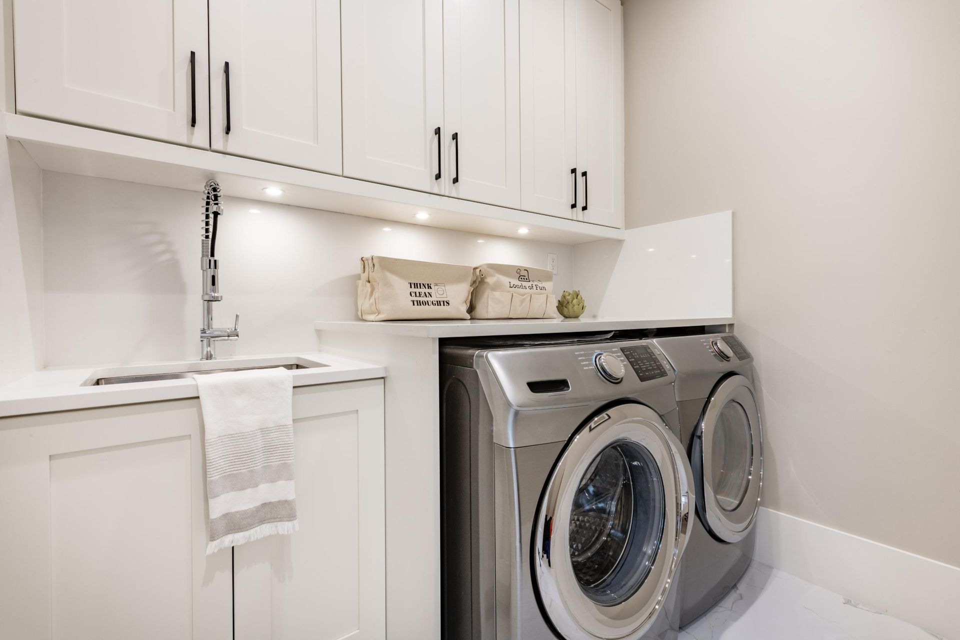 A laundry room with a washer and dryer and a sink.