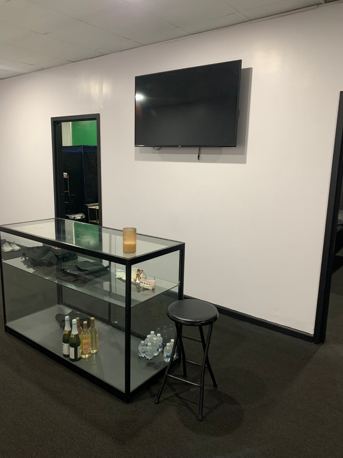 A room with a glass display case and a flat screen tv on the wall.