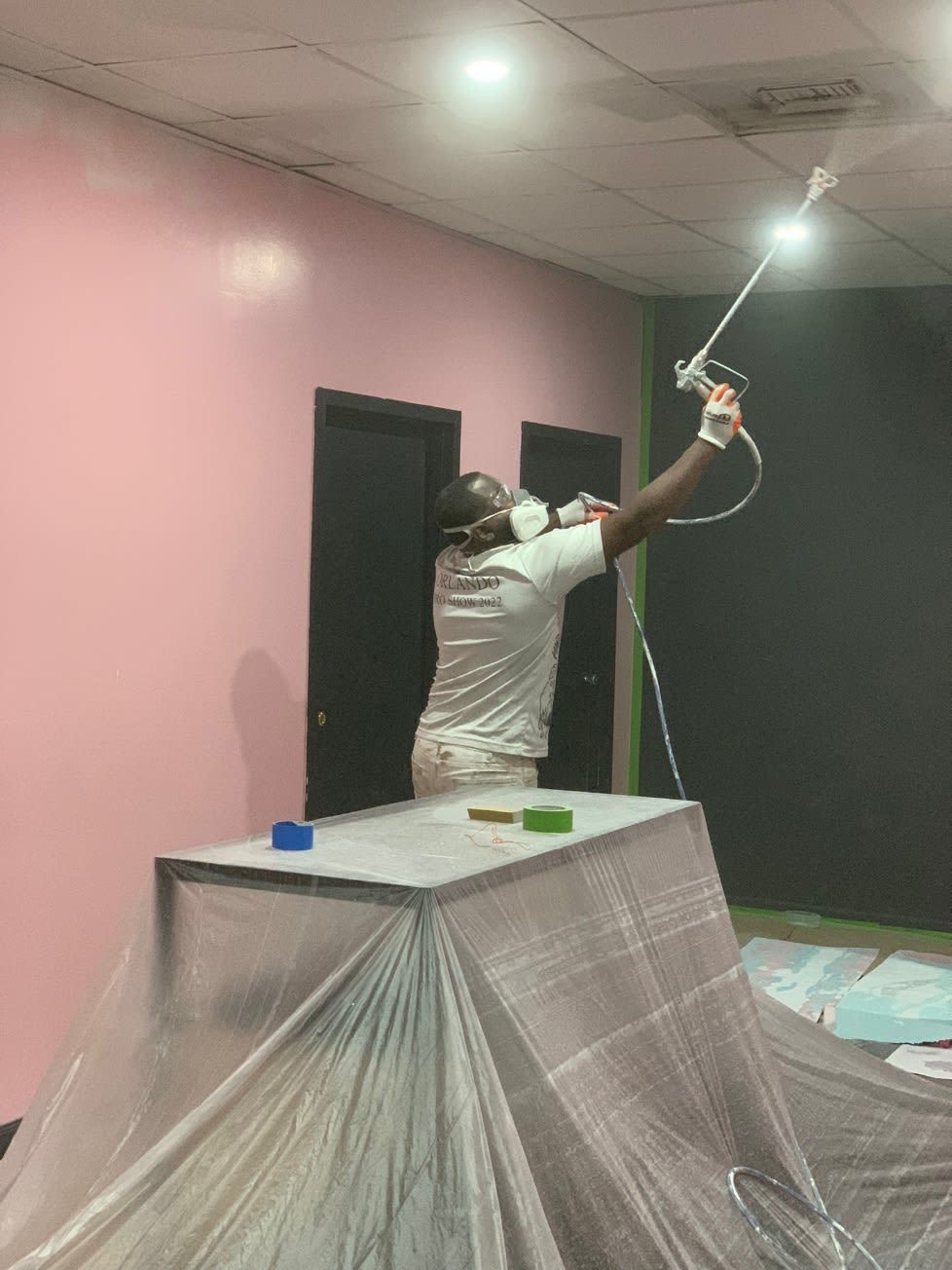 A worker is painting the ceiling inside the house.