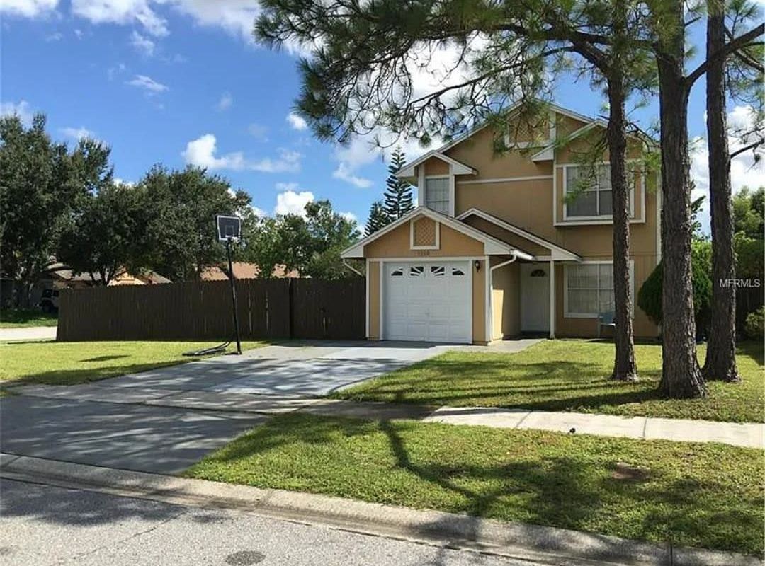 A house with a garage and a driveway in front of it.