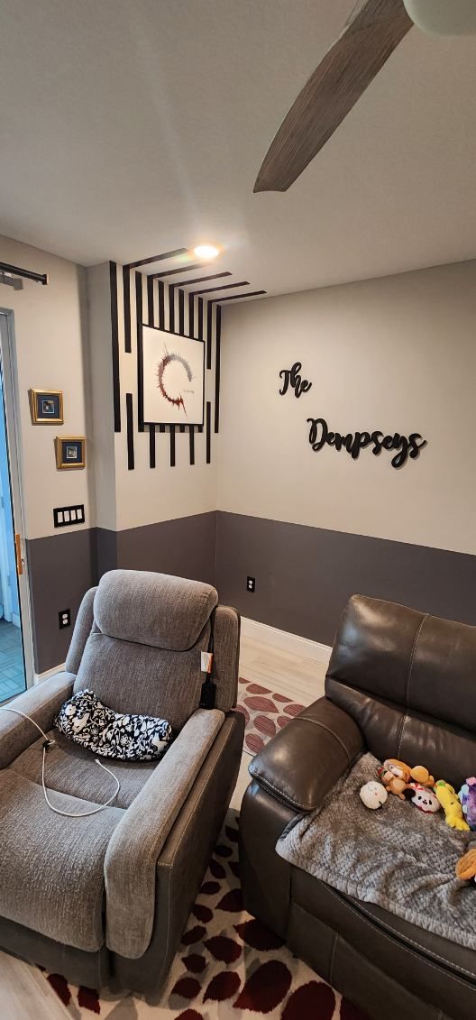 A living room with a couch , chair , and ceiling fan.