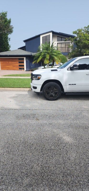 A white truck is parked in front of a house.