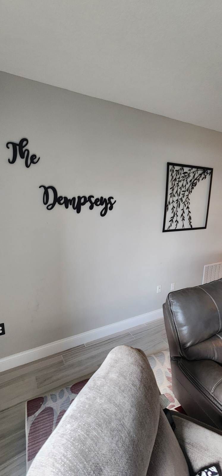 A living room with a couch and a wall with a name on it.