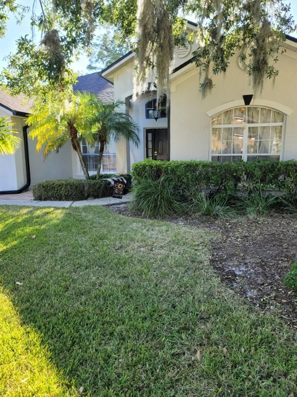 A white house with a lush green lawn in front of it.