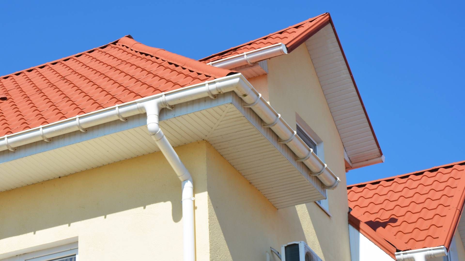 A house with a red tile roof and a white gutter