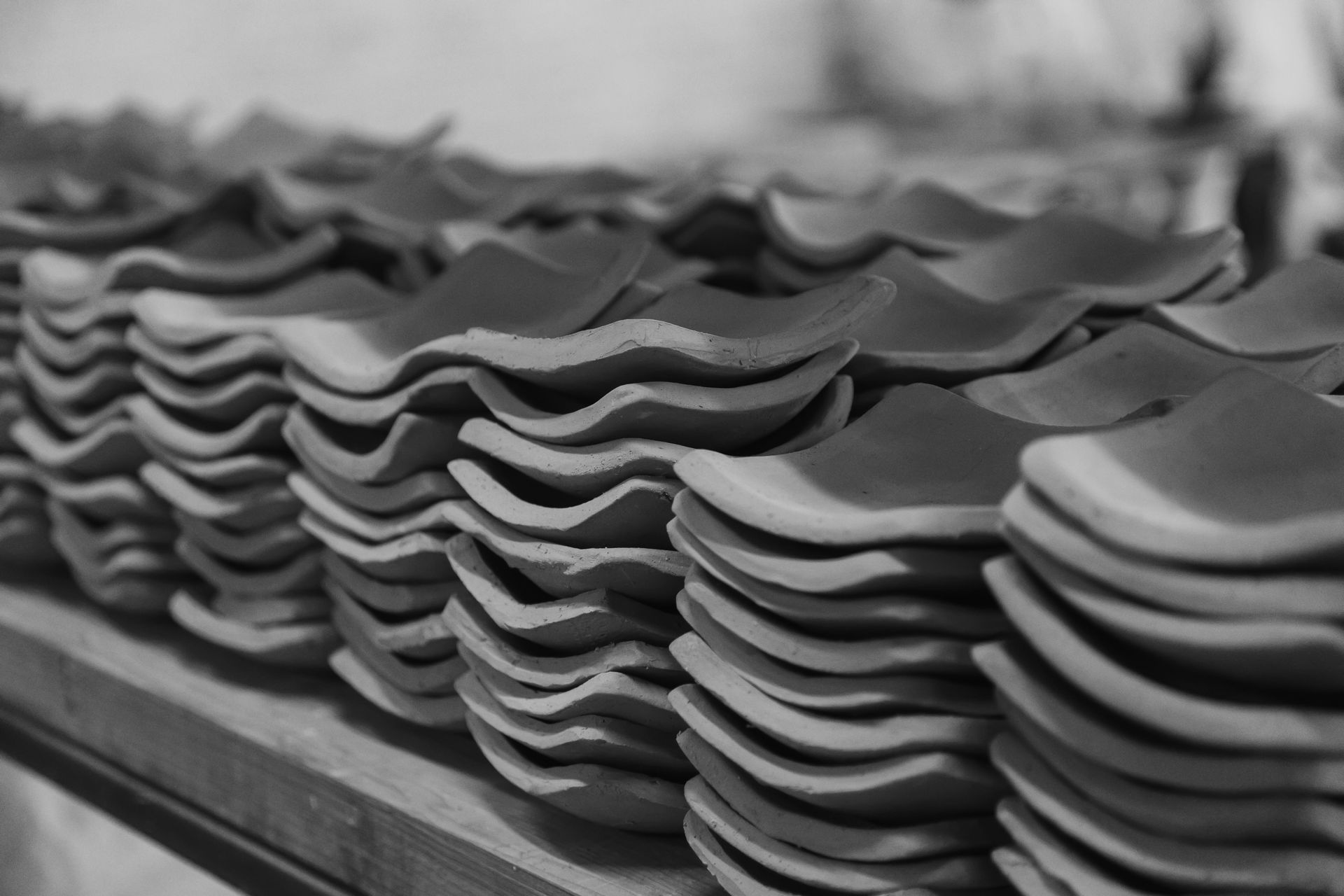 A black and white photo of stacks of plates on a table.