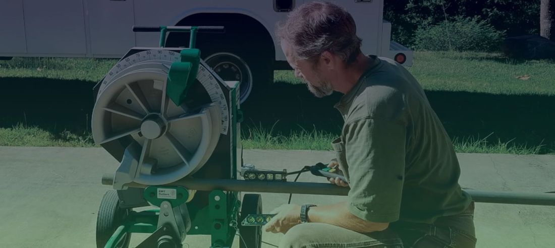 A man is kneeling down in front of a machine.