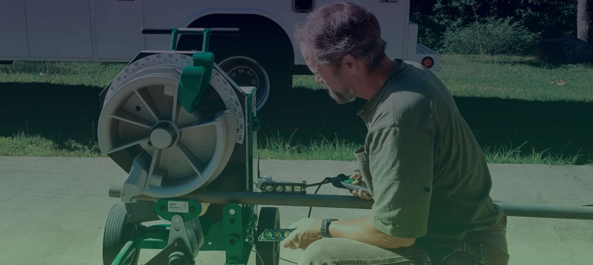 David Jones is kneeling down in front of a machine.