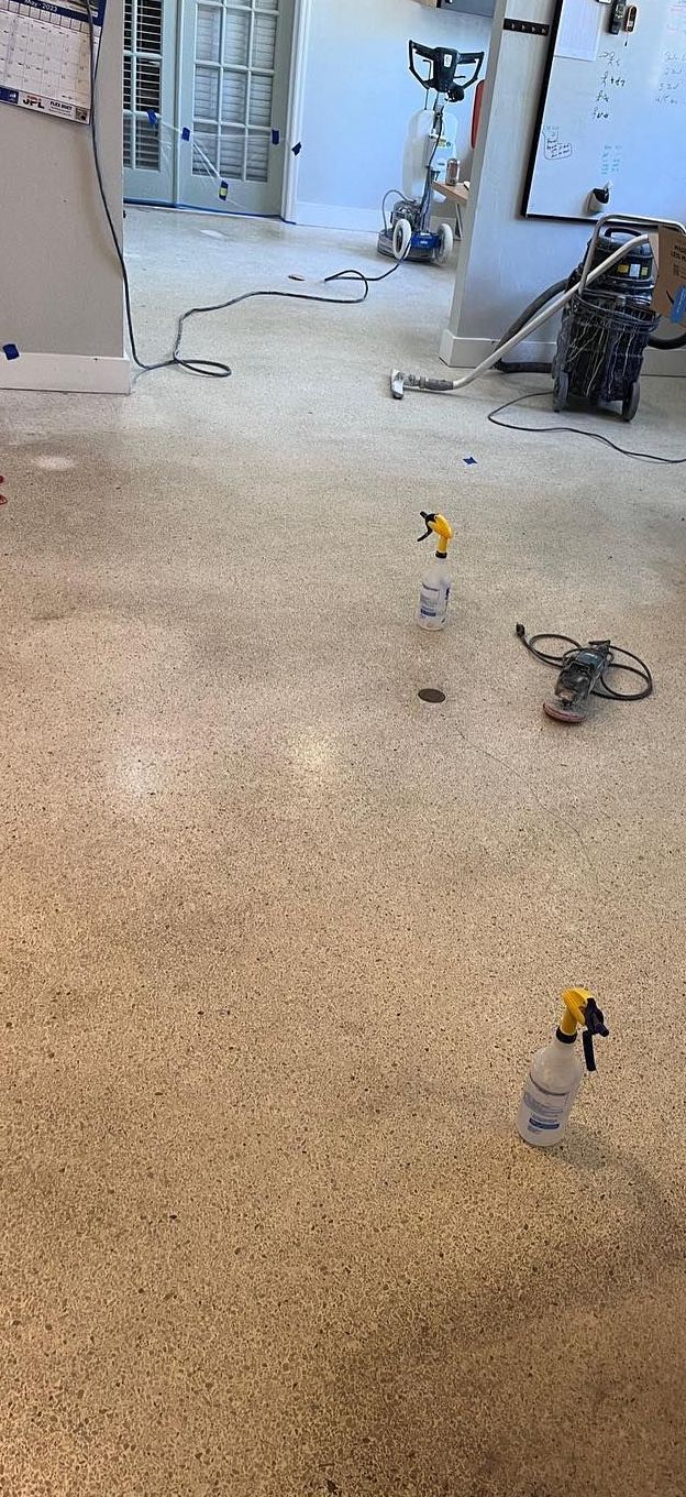 A room with a vacuum cleaner and spray bottles on the floor.