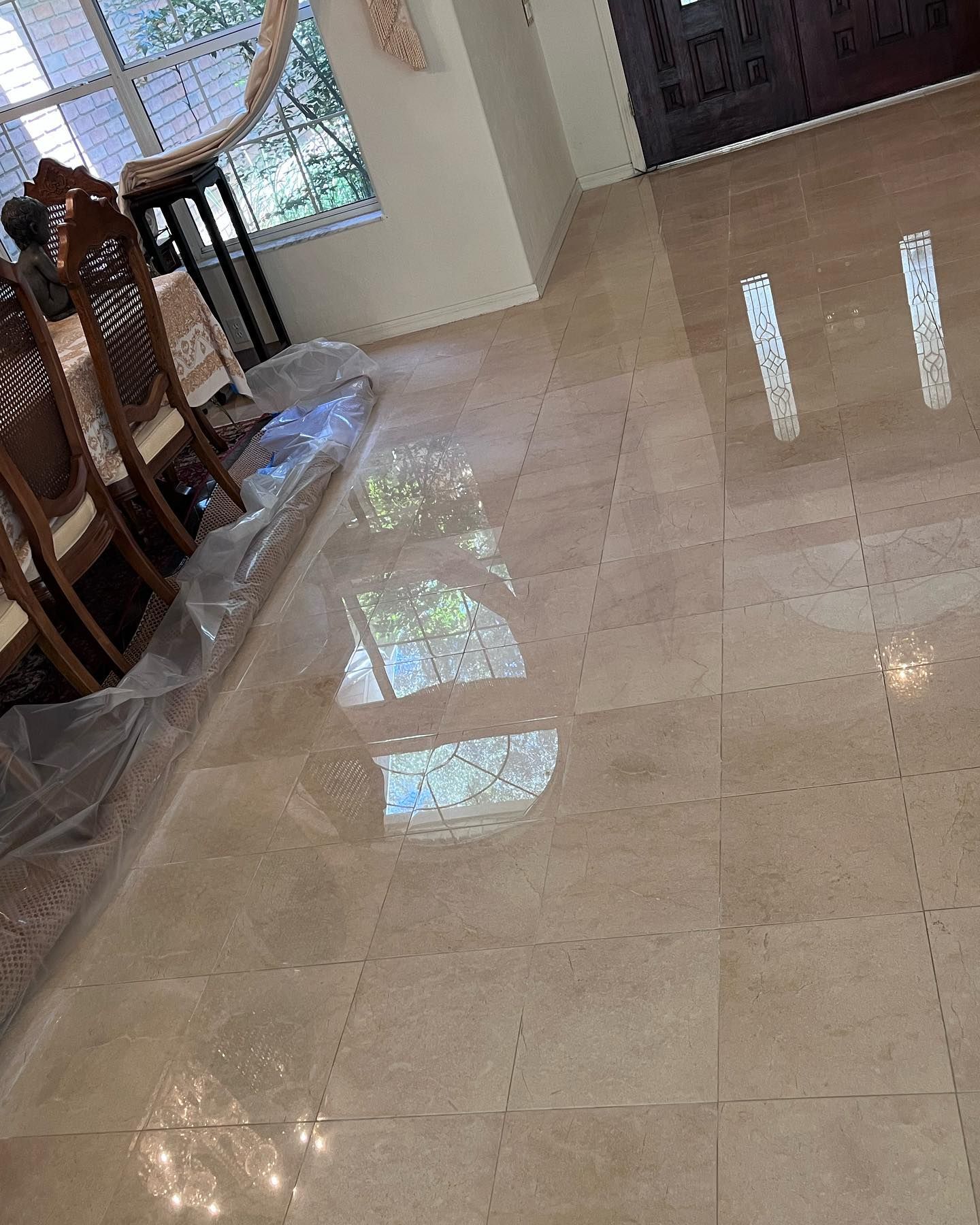 A dining room with a table and chairs and a marble floor.