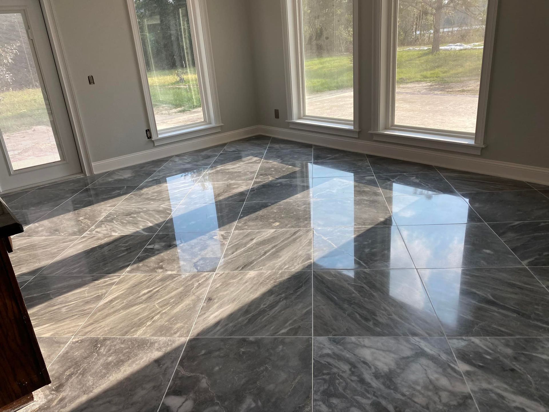 A room with a marble floor and a lot of windows.