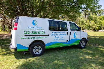 A white van is parked in a grassy field.