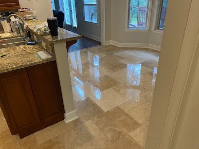 A kitchen with a granite counter top and a tile floor.