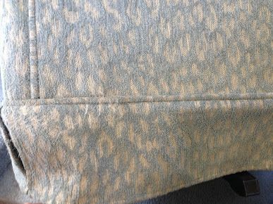 A close up of the back of a chair with a pattern on it.