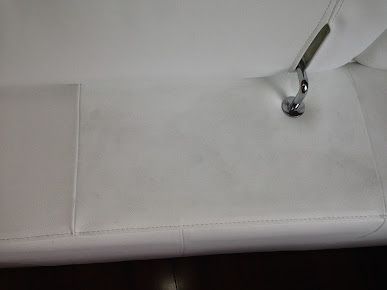 A close up of a white couch with a metal railing.