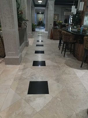 A hallway in a house with black and white tiles on the floor.