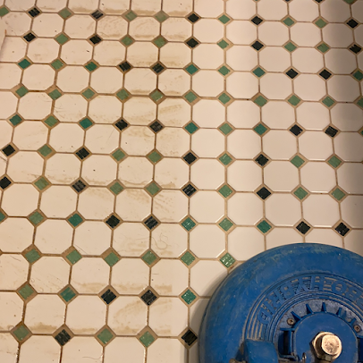 A blue mop is sitting on a tiled floor