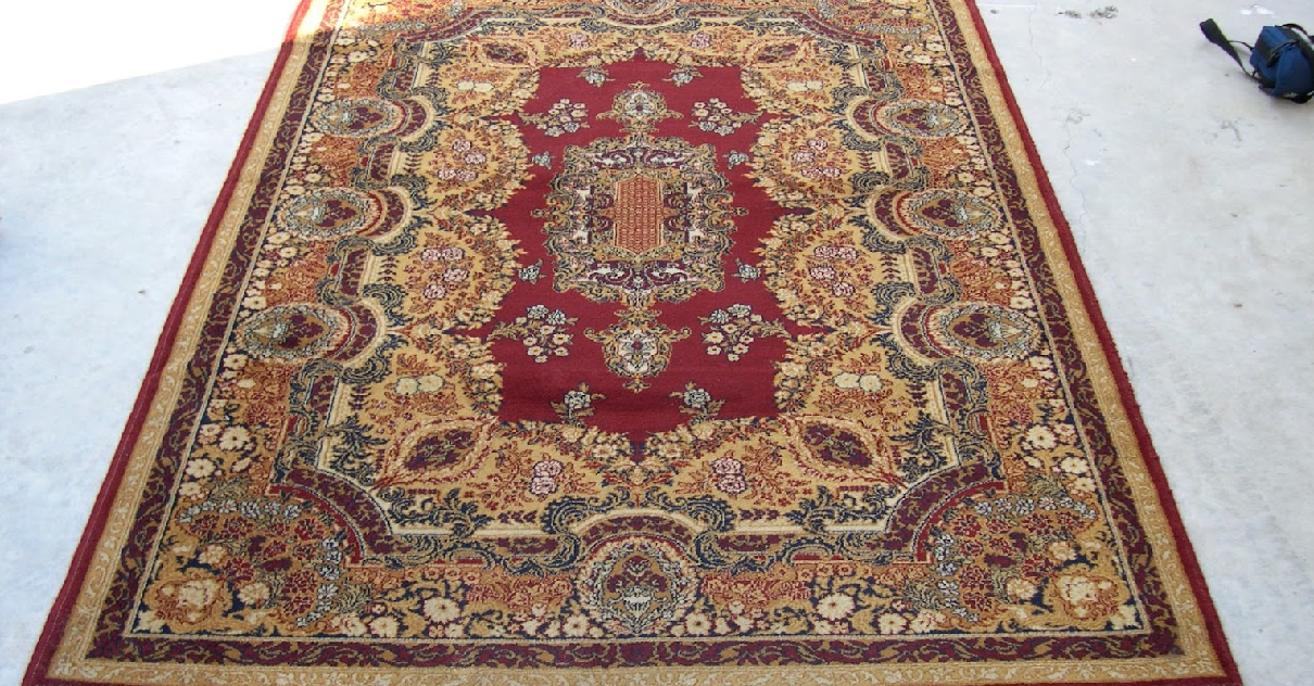 A rug with a red border is on the floor