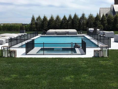 A large swimming pool surrounded by a fence in a backyard.