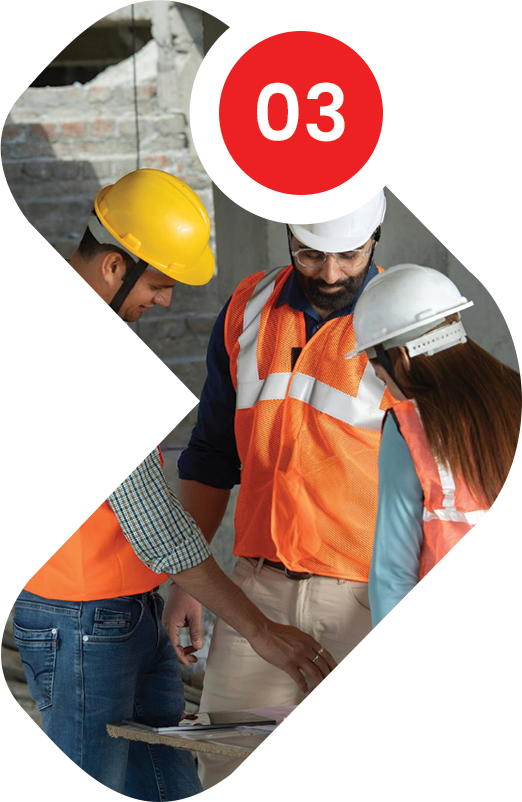 Construction workers in orange vests and hard hats reviewing plans.