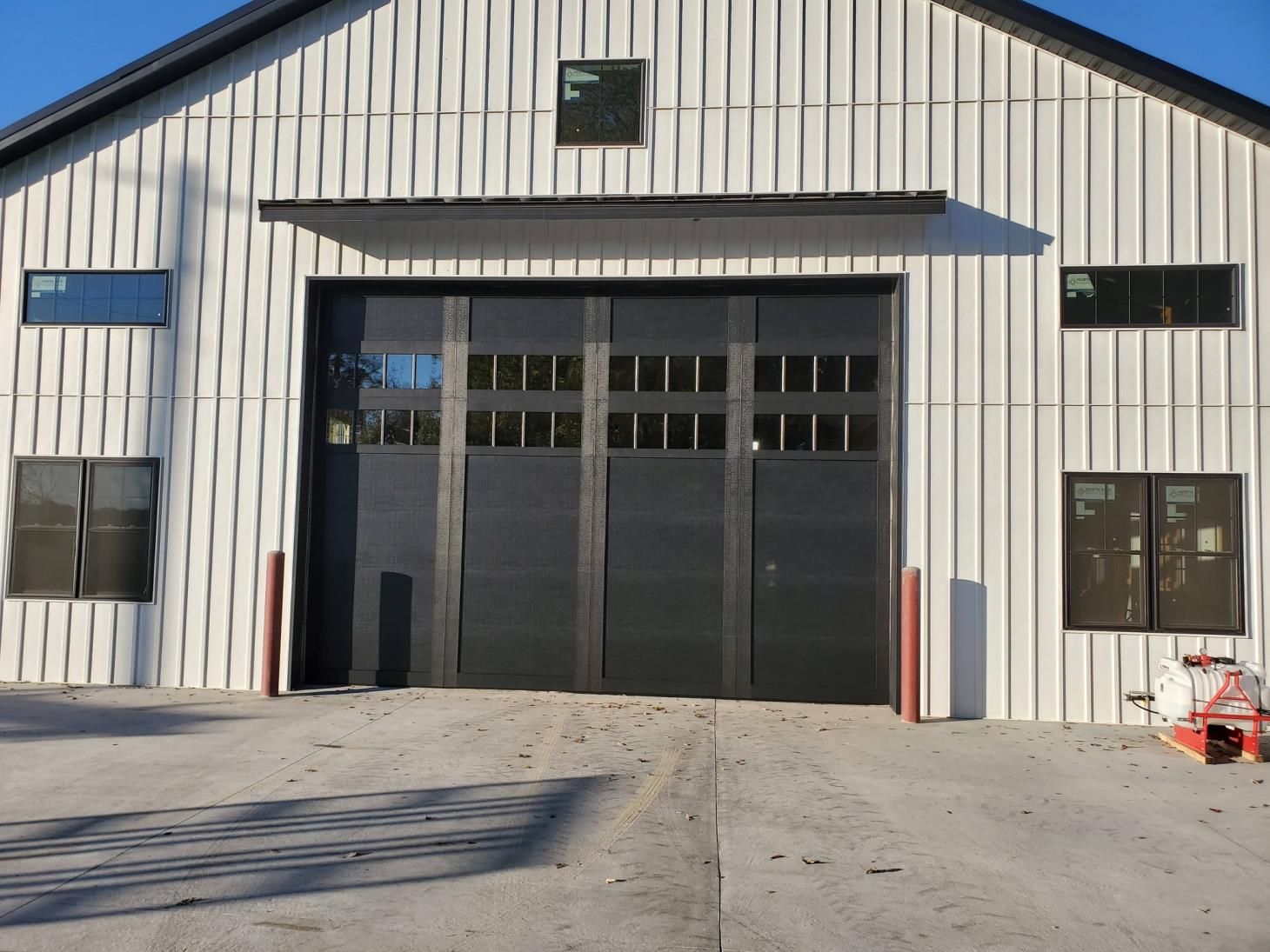 Yellow garage door with a textured surface and windows at the middle.