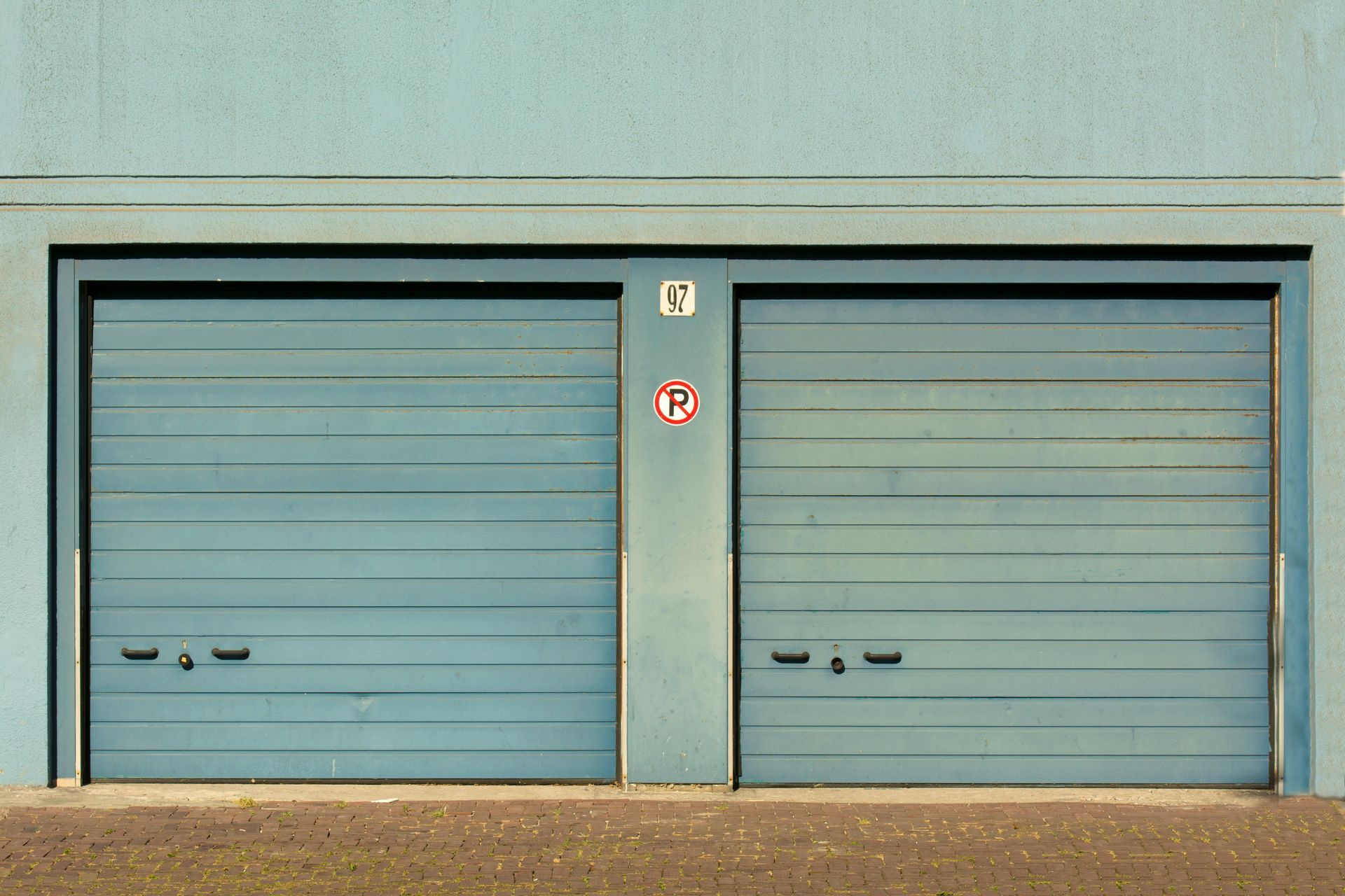 Yellow garage door with a textured surface and windows at the middle.