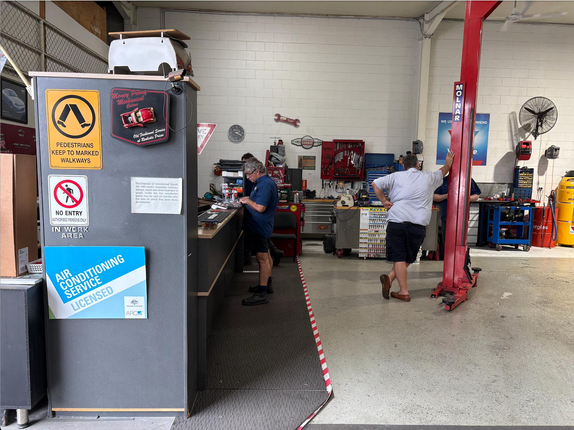 A Man Is Working on The Wiring of A Car — Monypenny Mechanical in Bungalow, QLD