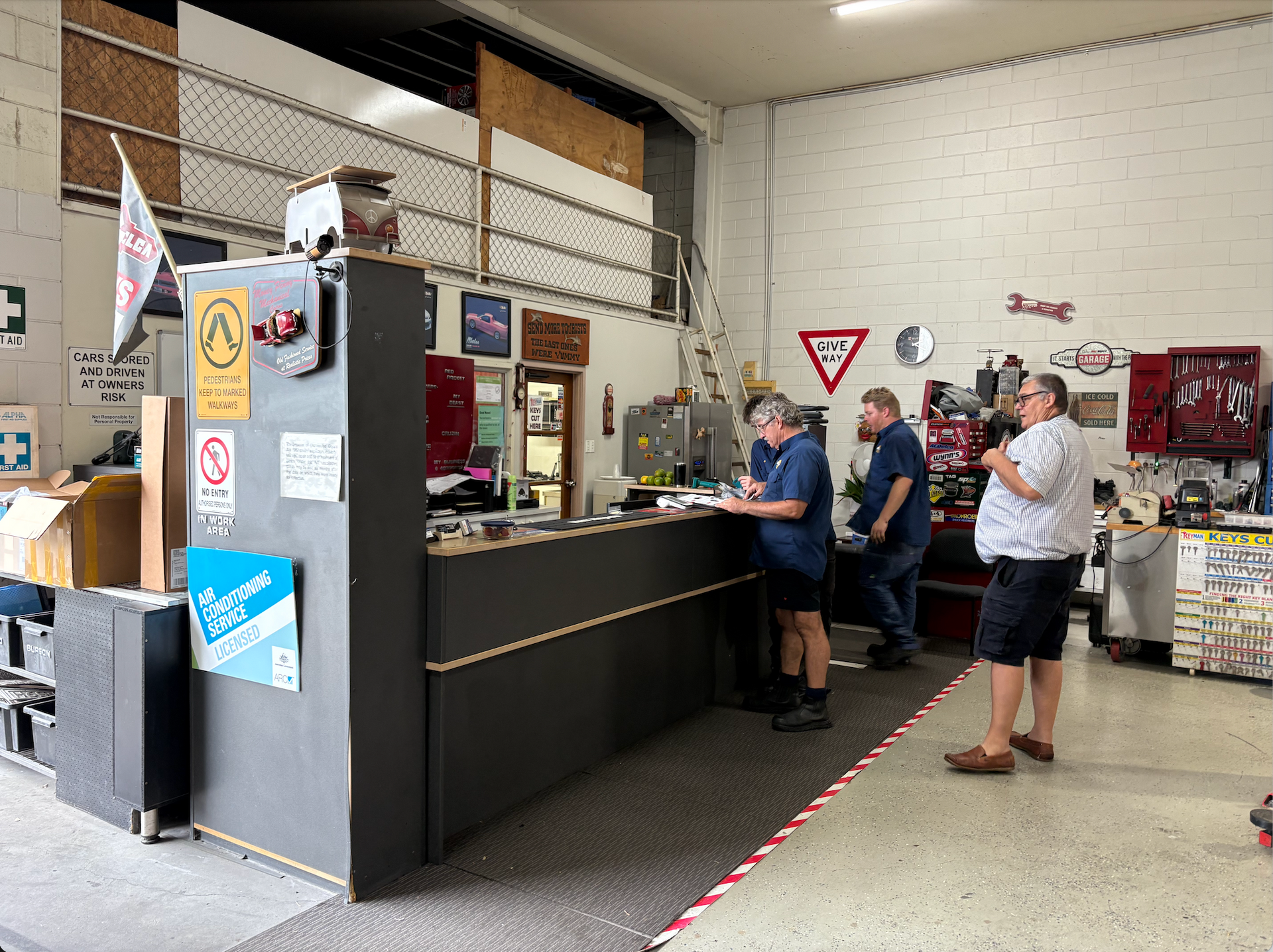 People Standing Around a Desk  — Monypenny Mechanical in Redlynch, QLD