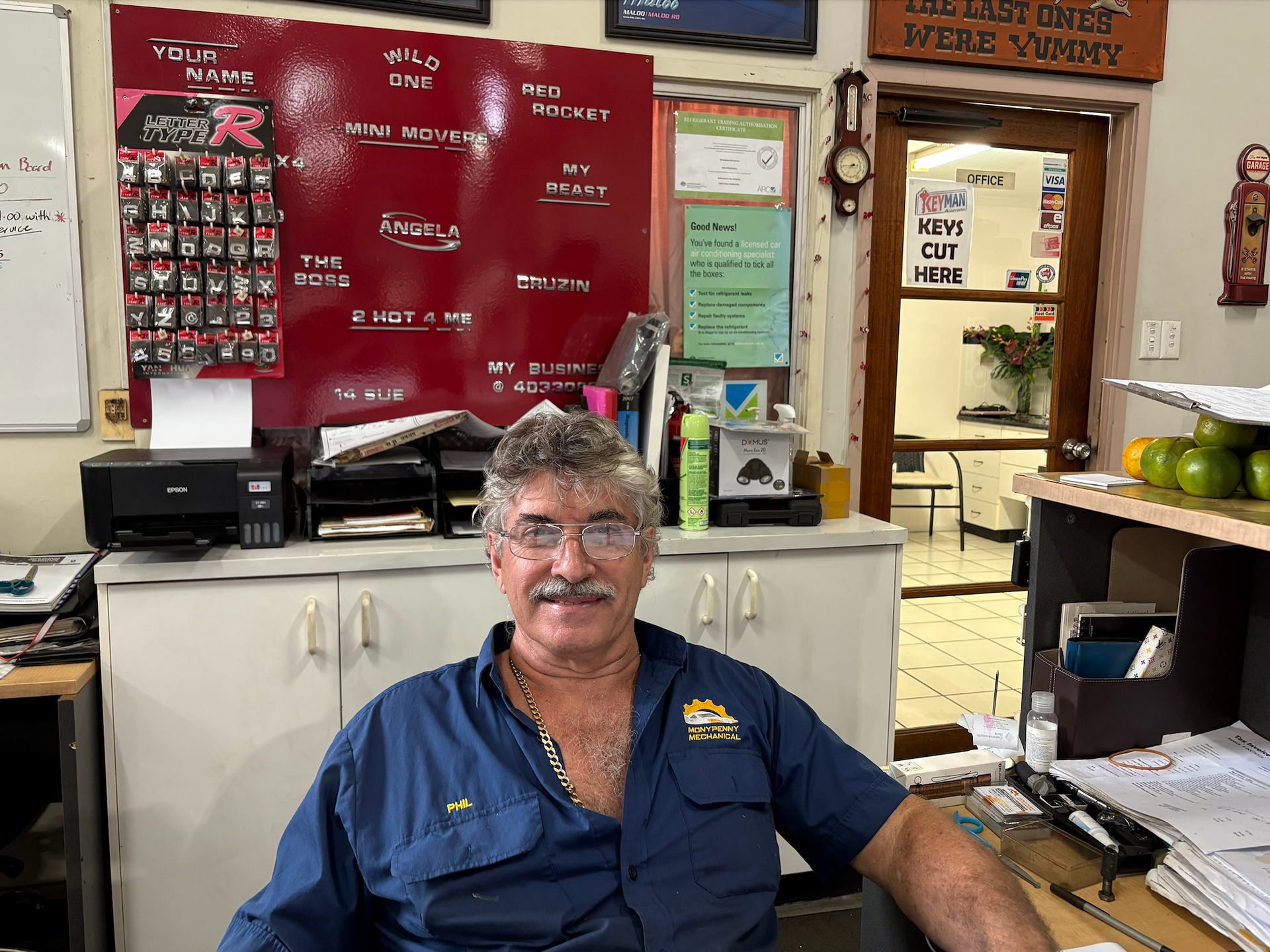 A Man Smiling while Sitting at a Desk — Monypenny Mechanical in Bungalow, QLD