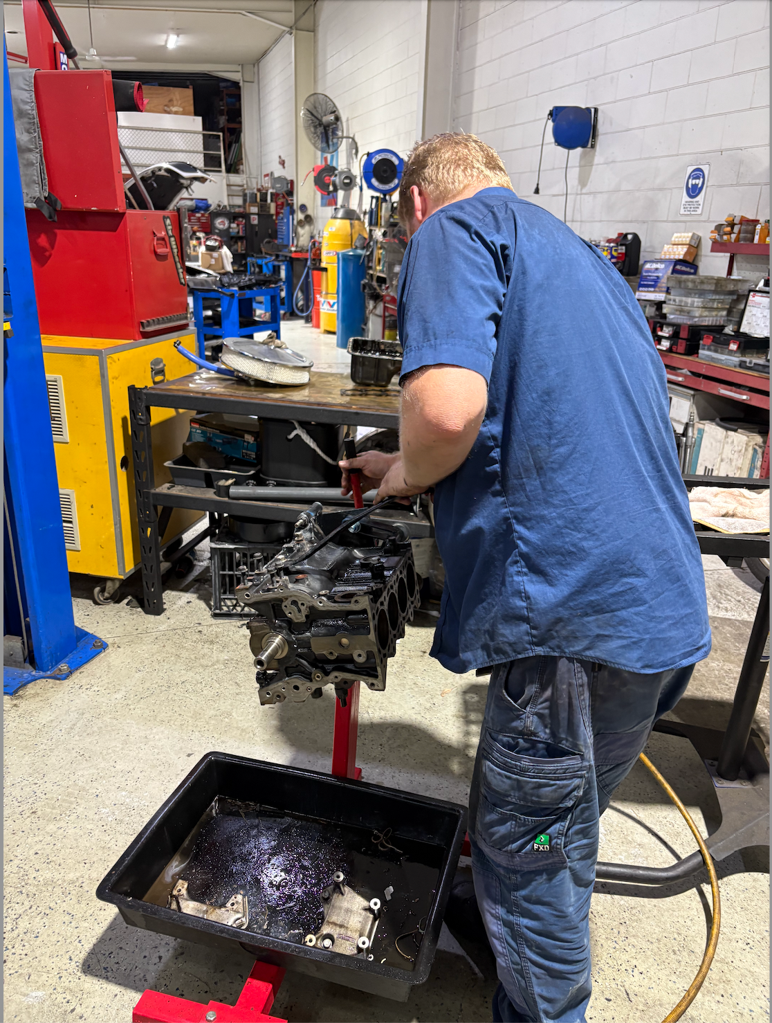 A Man Fixing a Car Engine — Monypenny Mechanical in Bungalow, QLD