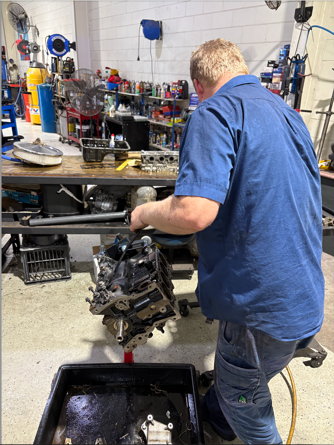 A Man Is Working on an Engine — Monypenny Mechanical in Bungalow, QLD