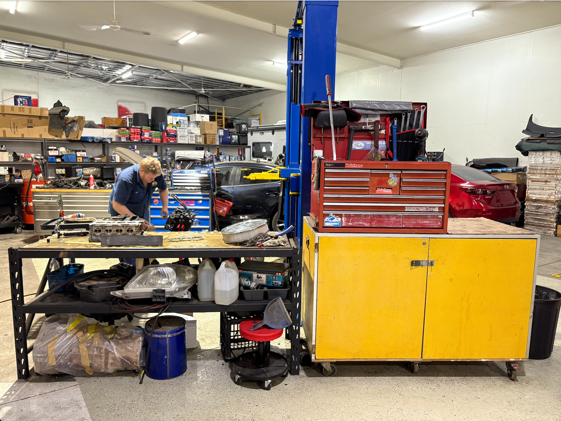 A Man Is Working on an Engine in A Garage — Monypenny Mechanical in Bungalow, QLD