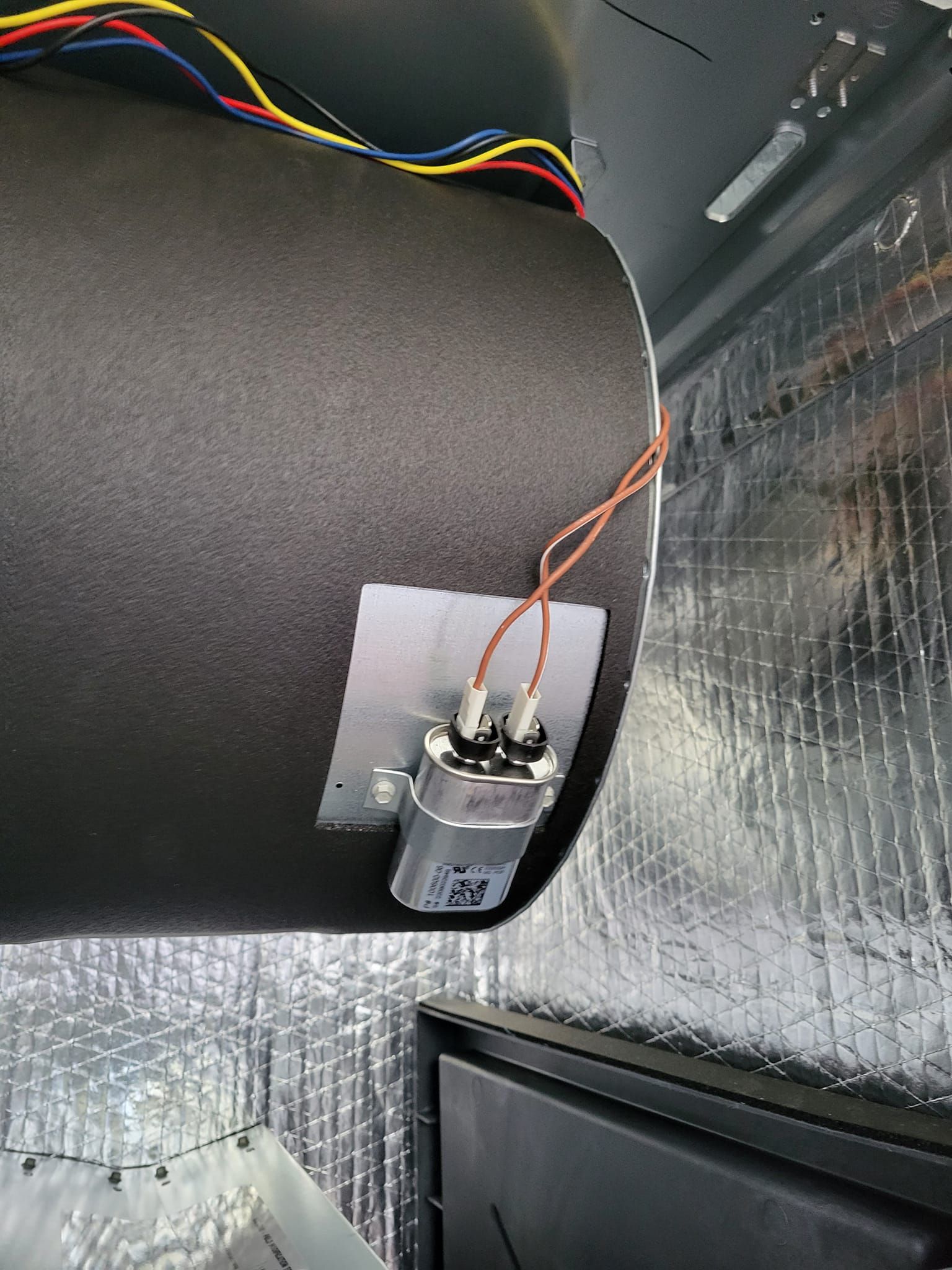 A close up of a black pipe with wires attached to it.