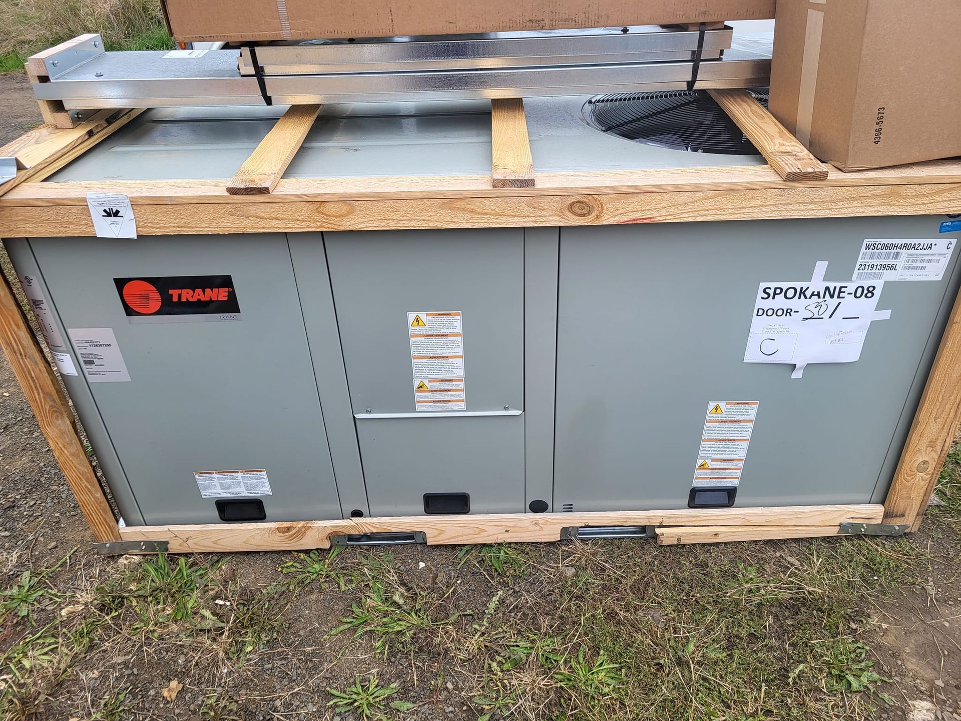 A large air conditioner is sitting on top of a wooden crate.