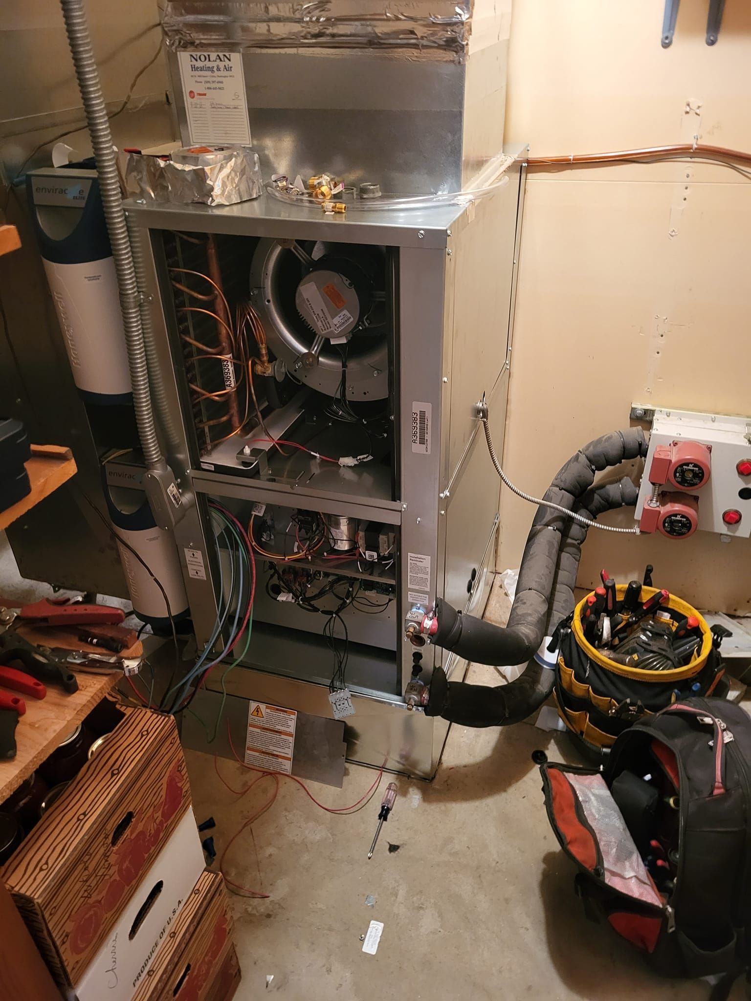 An air conditioner is being repaired in a room with tools.