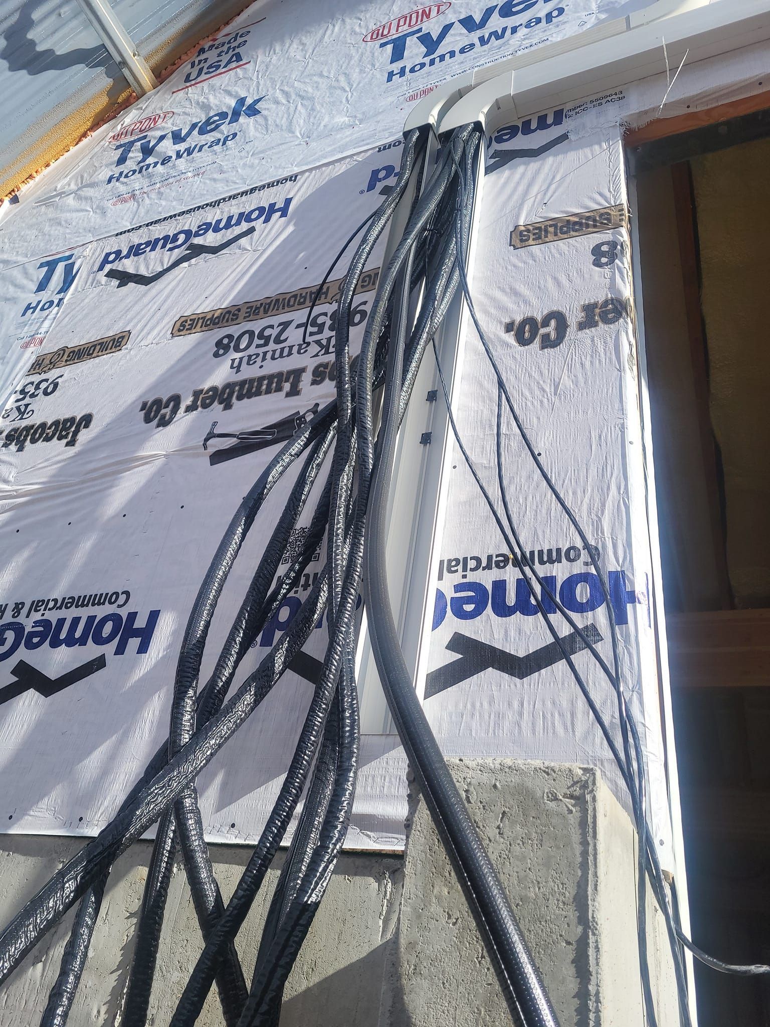 A bunch of wires are hanging from the side of a building