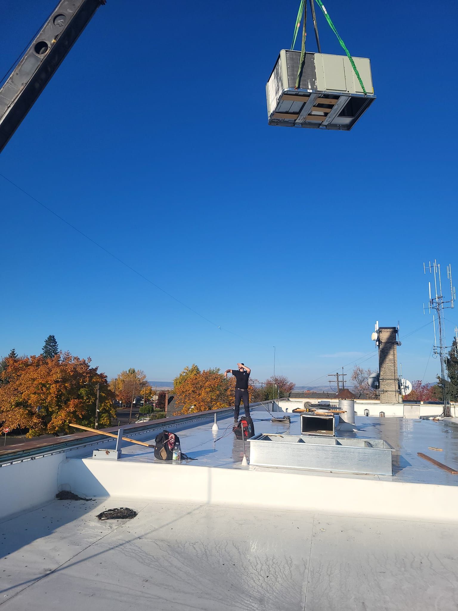 A crane is lifting a box that says bel on it
