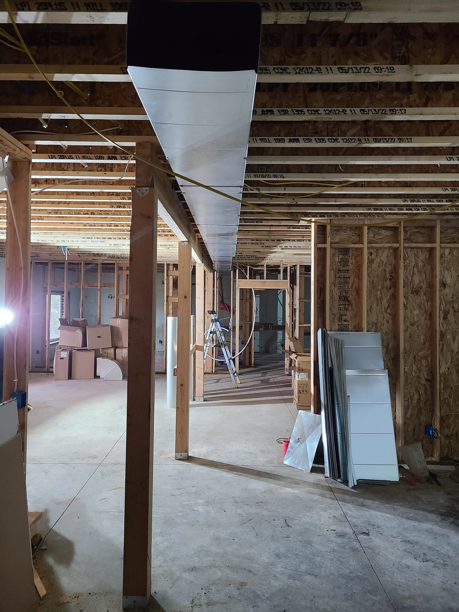 A room with a lot of wooden beams and boxes on the floor
