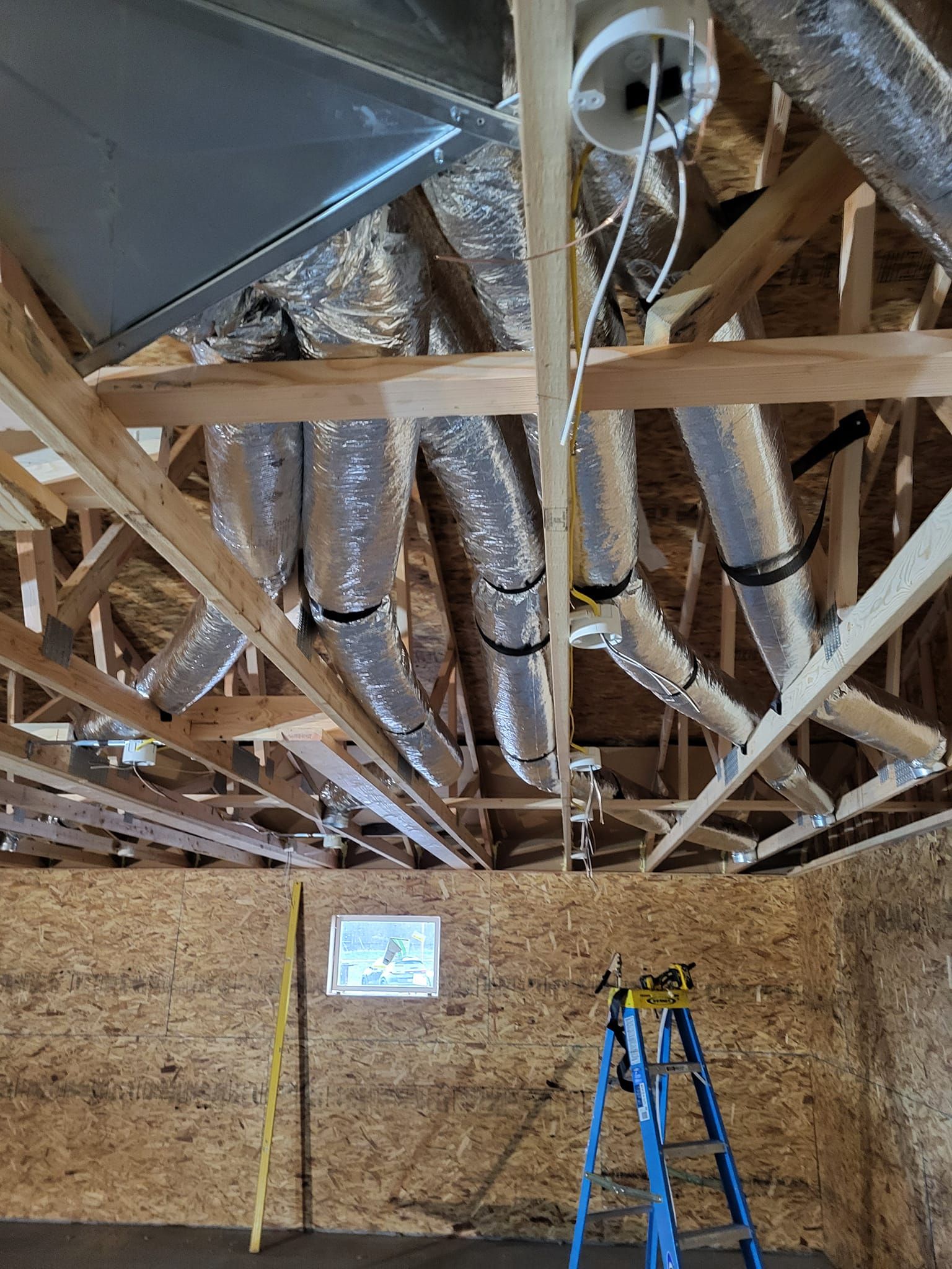 A ladder is sitting in the middle of a room under construction.