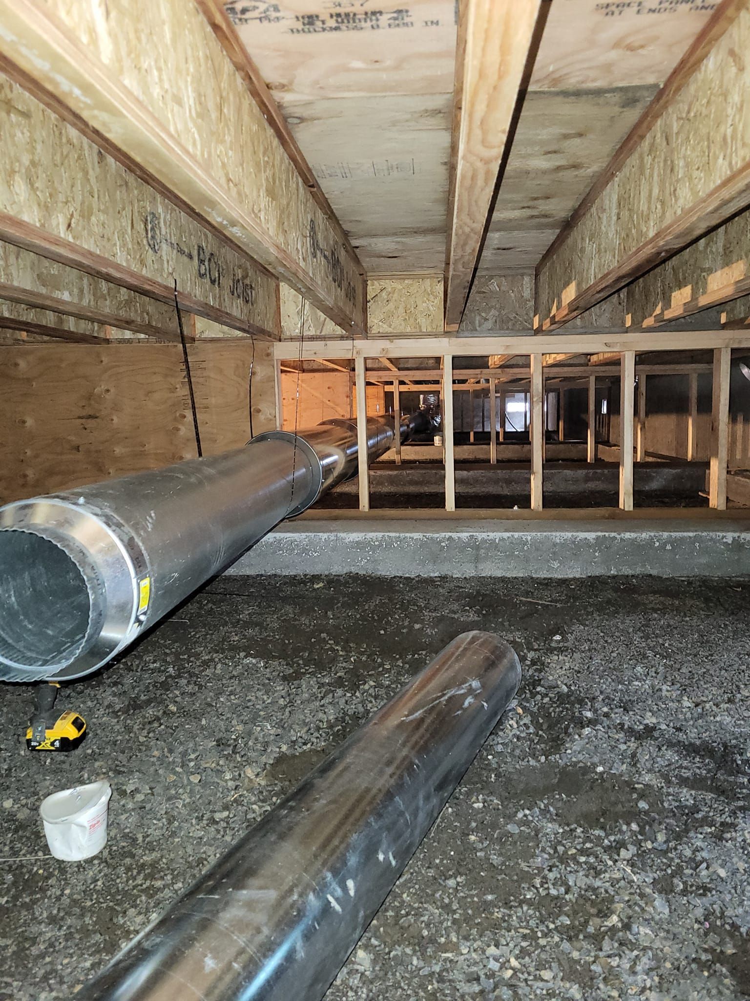 A bunch of pipes are laying on the ground in a room.