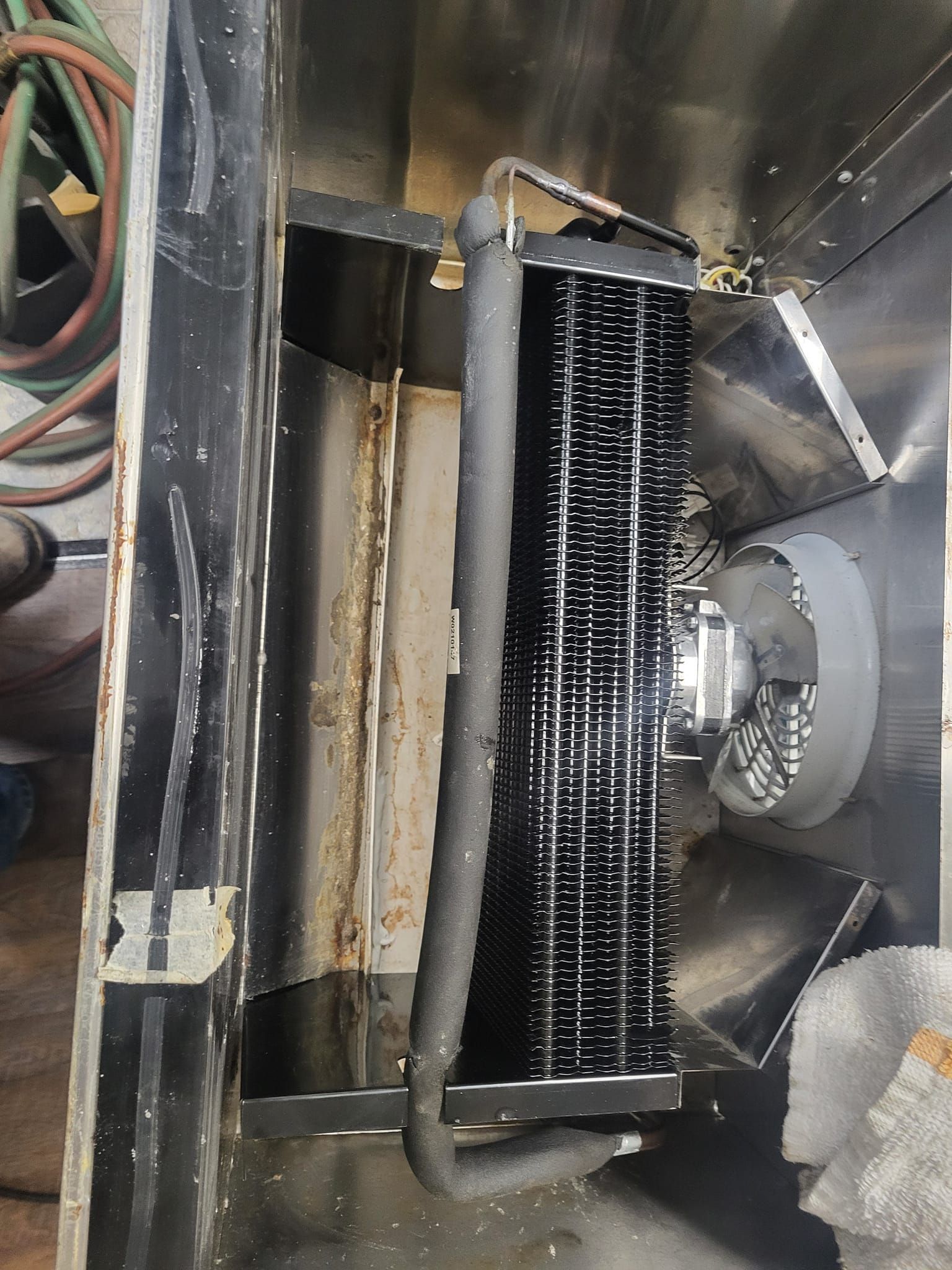 A close up of a stainless steel cooler with a fan attached to it.