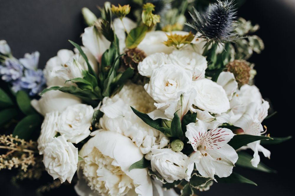 White and blue floral bouquet with green foliage, close-up shot.
