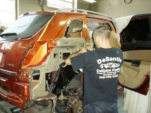 A man is working on a car in a garage.