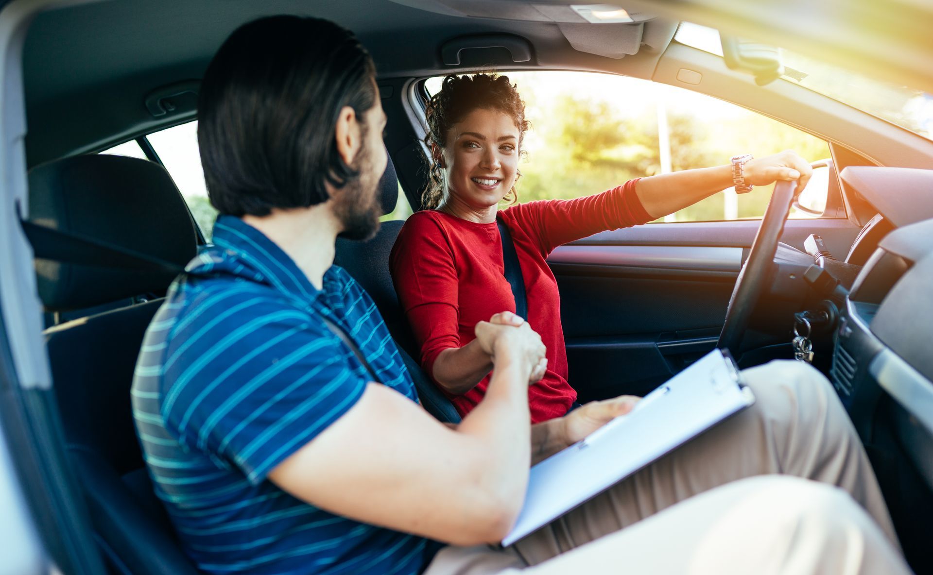 A man is teaching a woman how to drive a car.