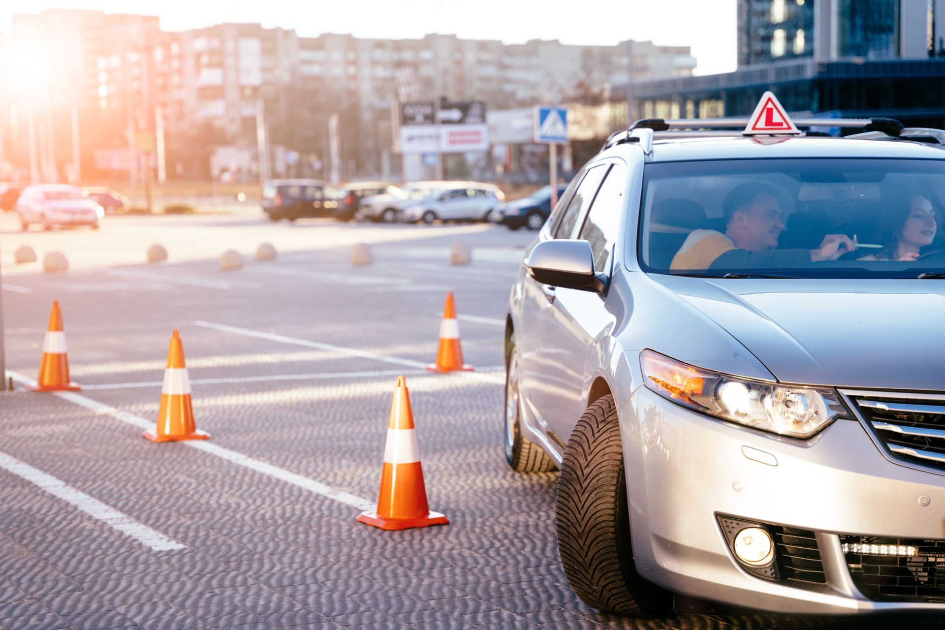 A car is driving down a street next to traffic cones.