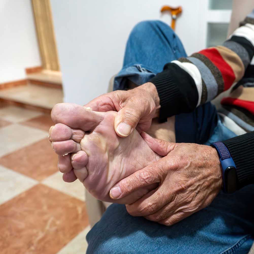 Senior man massaging his injured foot against pain